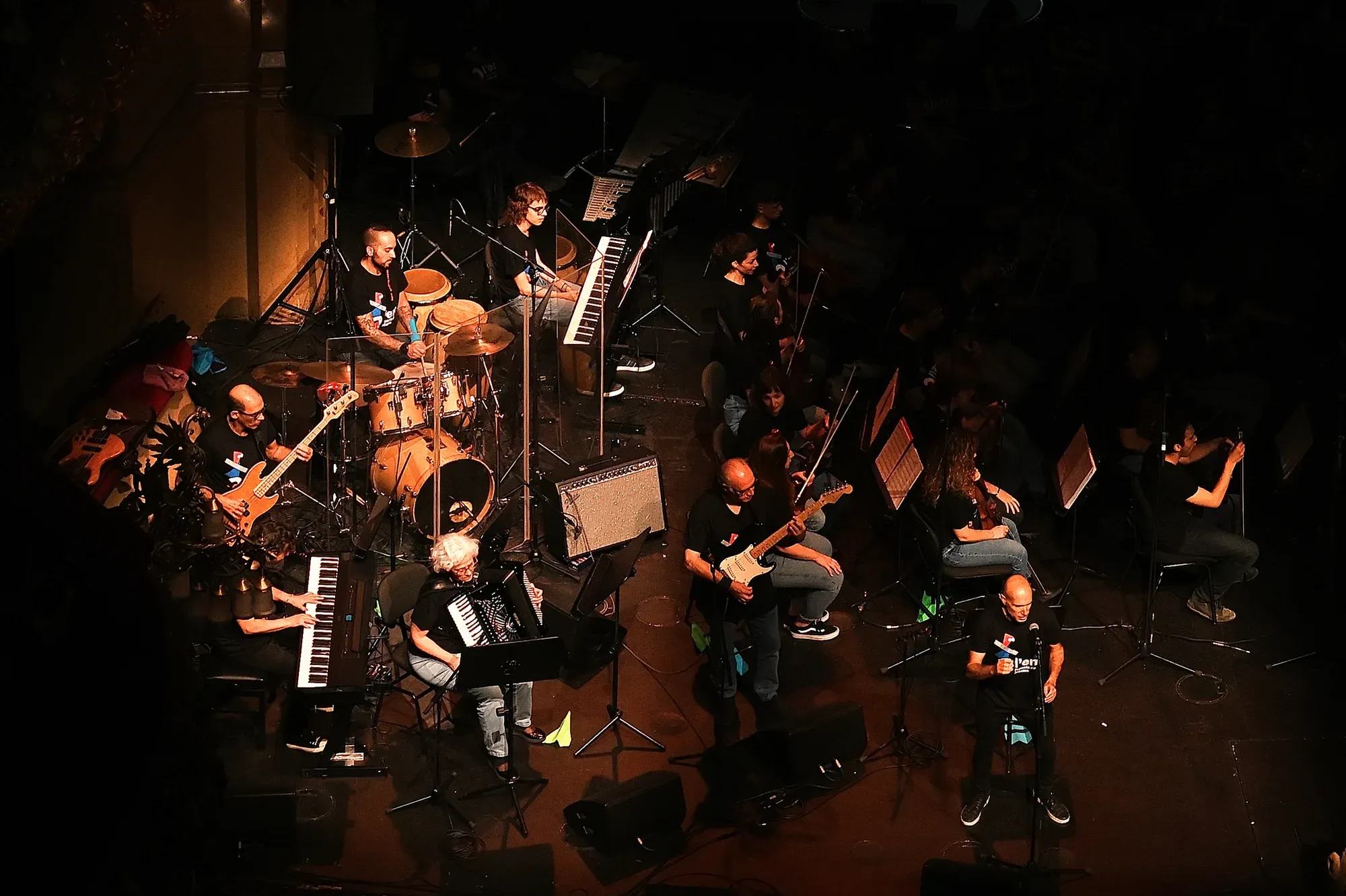 Grup instrumental tocant en un escenari amb teclats, guitarres i bateria