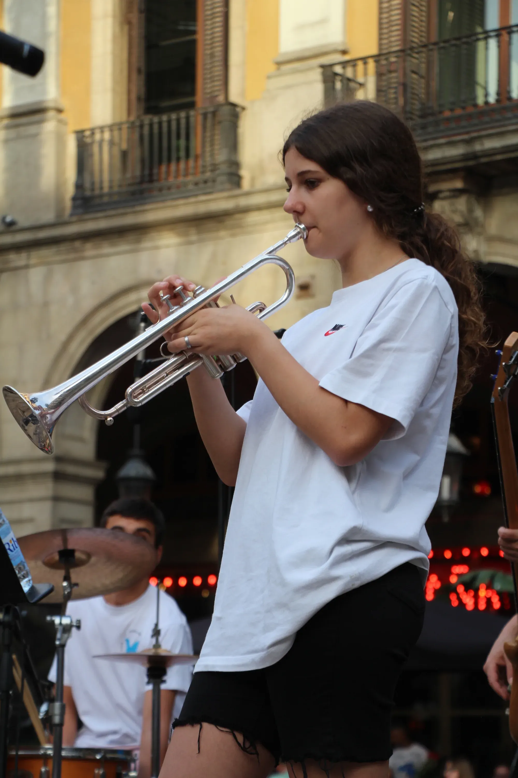 Alumna tocant la trompeta en un concert al carrer