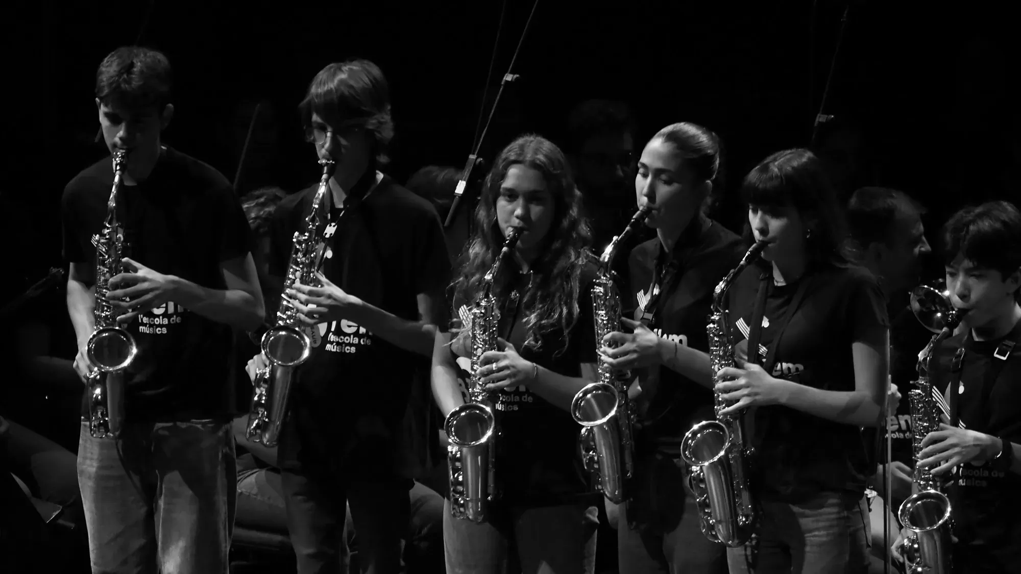Fila d’alumnes tocant el saxo en una actuació