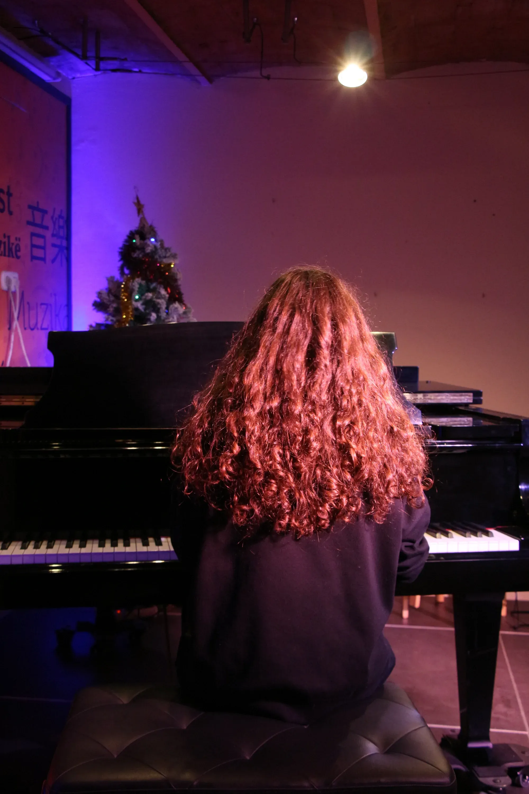 Alumna tocant un piano de cua