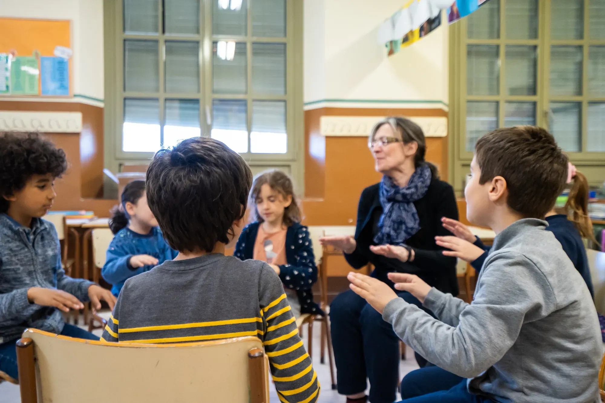 Una professora fa una classe de grup amb infants asseguts en rotllana