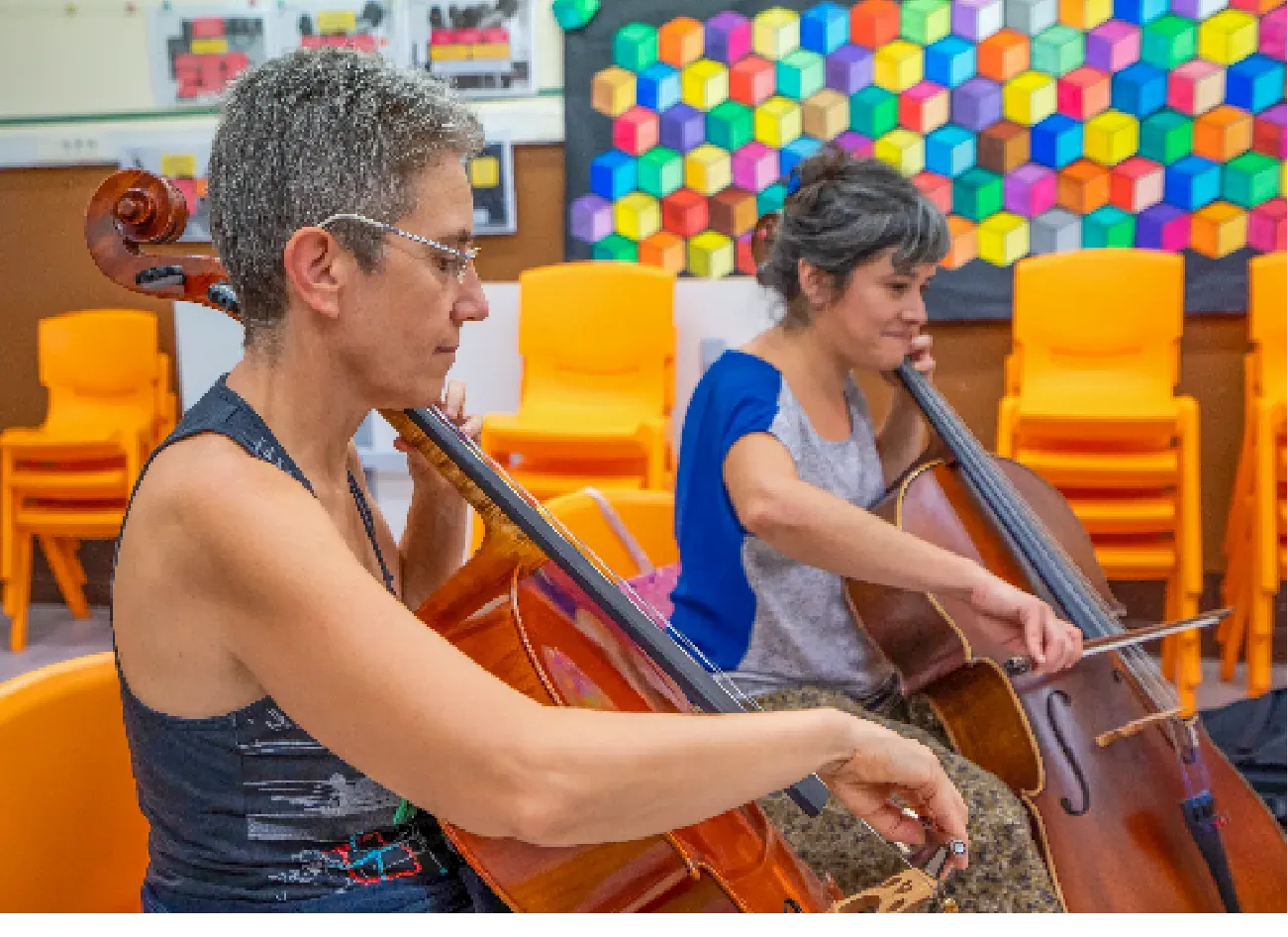 Dues violoncel·listes tocant en una aula de l’escola